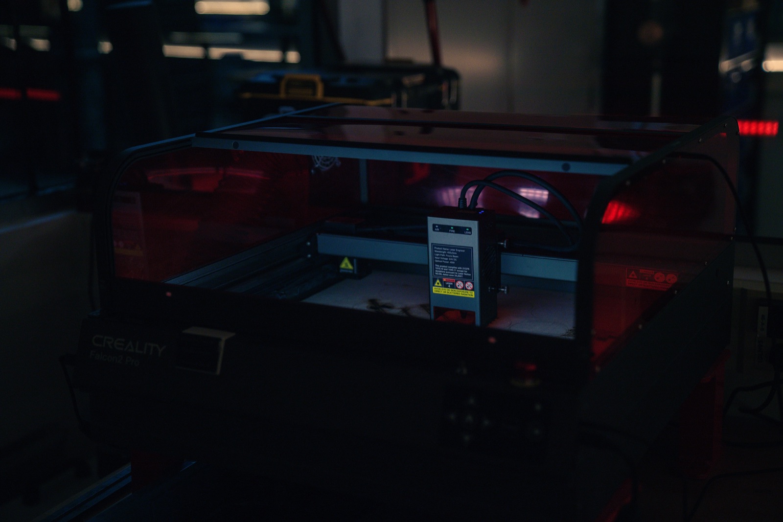 Laser cutter glowing red in a dark room