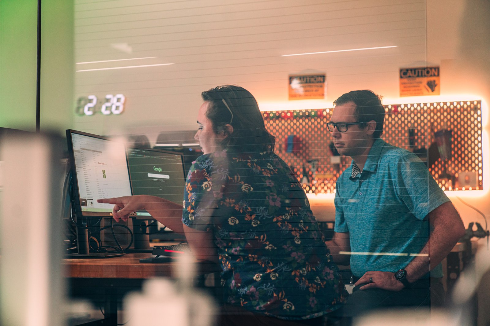 An instructor and a maker working through a TinkerCAD model at a computer