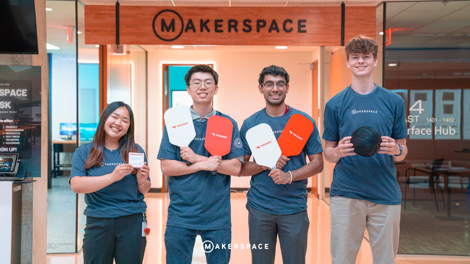 Winners holding their prizes at the Makerspace entrance